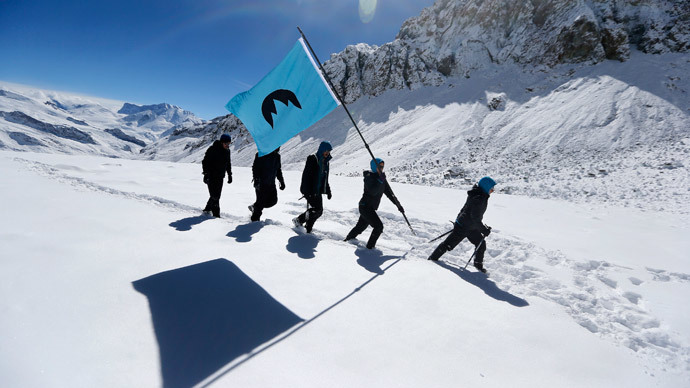 Greenpeace activists walk as they hold a flag on Olivares glacier for the symbolic founding of "Republica Glaciar" (Glacier Republic), some 5,000 meters (16,404 ft.) above sea level, at Los Andes Mountain range, near Santiago city, March 2, 2014.(Reuters / Ivan Alvarado )