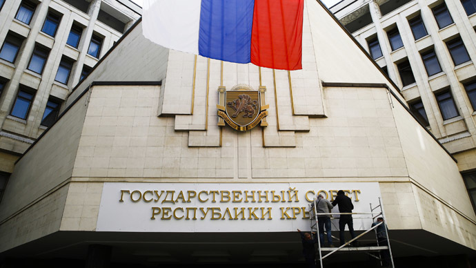 Workers put up a new sign at the local parliament building in Simferopol March 19, 2014. (Reuters)