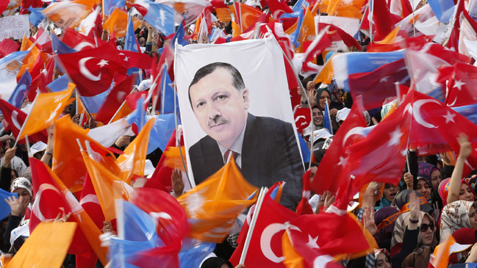 Supporters hold up a portrait of Turkey's Prime Minister Tayyip Erdogan while waving Turkish and AK Party (AKP) flags during an election rally in Istanbul March 23, 2014. (Reuters)