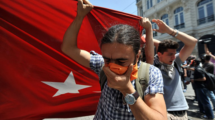 Protestors hold a giant Turkish flag in front of a water cannon truck on May 31, 2013 during a protest against the demolition of Taksim Gezi Park, in Taksim Square in Istanbul. (AFP Photo / Ozan Kose)