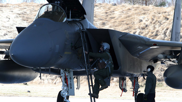A pilot of US F15C Eagle jet fighter climbs into the fighter before take off during the Lithuanian - NATO air force exercise at the air force base near Siauliai Zuokniai, Lithunaia, on April 1, 2014. (AFP Photo / Petras Malukas)