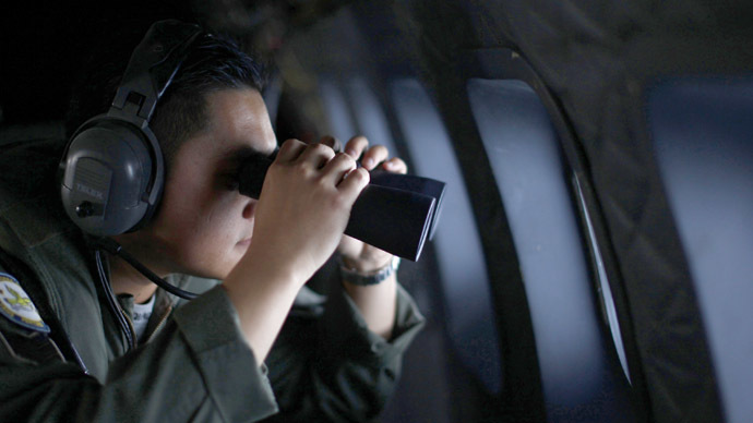 A crew member from the Royal Malaysian Air Force uses binoculars onboard a Malaysian Air Force CN235 aircraft during a Search and Rescue (SAR) operation to find the missing Malaysia Airlines flight MH370, in the Straits of Malacca March 13, 2014. (Reuters)