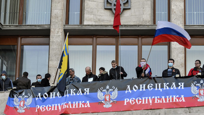 Pro-Russian protesters hang a banner and wave flags as they storm the regional government building in Donetsk April 6, 2014. (Reuters)