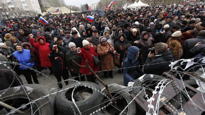 Pro-Russian activists stand in front of a barricade outside the regional state administration building in Donetsk, eastern Ukraine, on April 12, 2014 (AFP Photo / Max Vetrov)