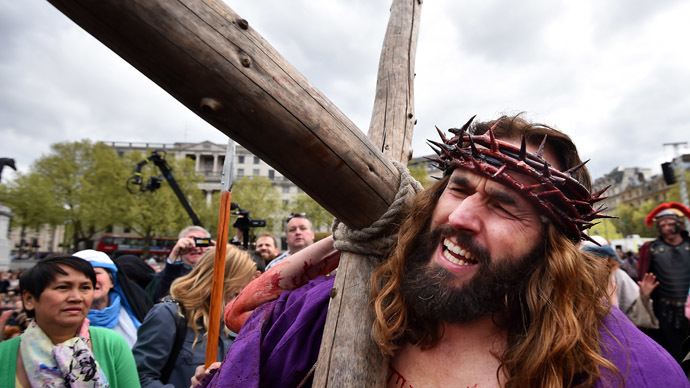 Actor James Burke-Dunsmore carries the cross as he performs the role of Jesus in 'The Passion of Jesus' by the Wintershall Players on Good Friday to crowds in Trafalgar Square in central London on April 18, 2014. (AFP Photo)