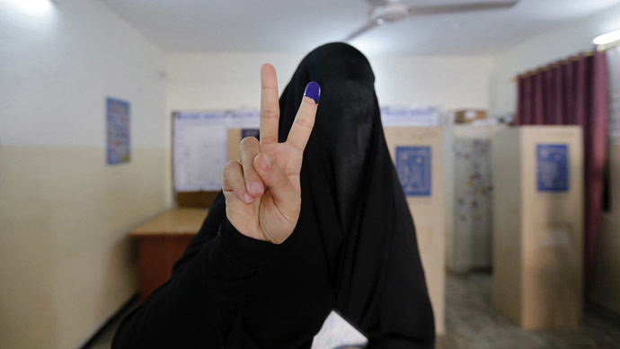 A fully-veiled woman shows her ink-stained finger at a polling station during voting for Iraqi parliamentary election in Baghdad April 30, 2014. (Reuters)
