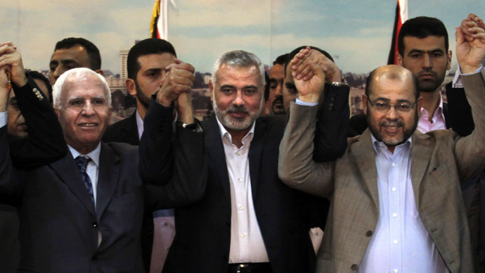 (From L to R) Palestinian Fatah delegation chief Azzam al-Ahmed, Hamas prime minister in the Gaza Strip Ismail Haniya and Hamas deputy leader Musa Abu Marzuk pose for a photo as they celebrate in Gaza City on April 23, 2014 after West Bank and Gaza Strip leaders agreed to form a unity government within five weeks as peace talks with Israel face collapse. (AFP Photo)