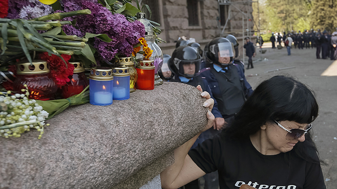 A woman stands next to flowers and lit candles placed in memory of people killed in recent street battles outside a trade union building in Odessa, May 3, 2014. (Reuters / Gleb Garanich)