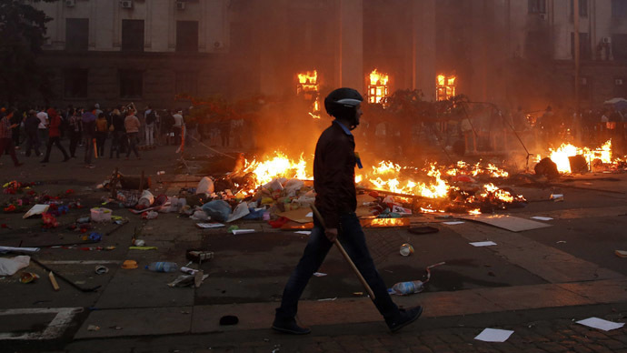 A protester walks past a burning tent camp and a fire in the trade union building in Odessa May 2, 2014. (Reuters / Yevgeny Volokin)
