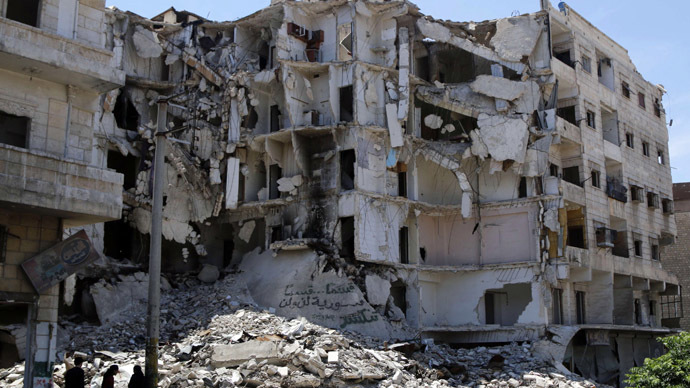 People stand along a damaged street in Bustan al-Basha district in Aleppo May 19, 2014 (Reuters/Hosam Katan)
