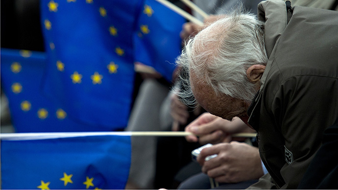 An elderly man slouches as other supporters hold EU flags during a campaign rally for the Christian Democratic Union (CDU) attended by the German chancellor ahead of European Parliament elections due to take place on May 25, 2014 (AFP Photo / John Macdougall)
