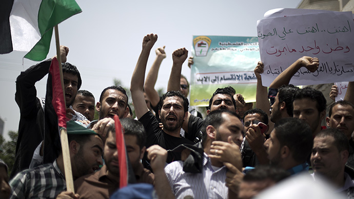 Palestinian protesters chant slogans to speed up the implementation of the national reconciliation and the announcement of the formation of a national unity government, during a rally in Gaza City on May 27, 2014. (AFP Photo / Mohammed Abed)
