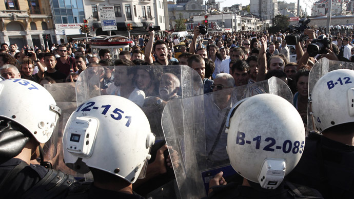 Riot police guard the entrance of Gezi Park as anti-government protesters shout slogans at Taksim square in central Istanbul July 20, 2013. (Reuters/Osman Orsal)