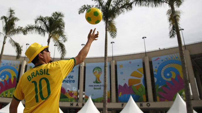 A street busker throws a soccer ball in the air outside the Maracana stadium in Rio de Janeiro ahead of the 2014 World Cup, June 6, 2014. (Reuters/Paul Hanna)