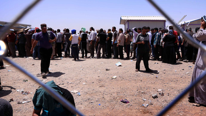 Iraqi families fleeing violence in the northern Nineveh province gather at a Kurdish checkpoint in Aski kalak, 40 kms West of Arbil, in the autonomous Kurdistan region, on June 10, 2014.(AFP Photo / Safin Hamed)