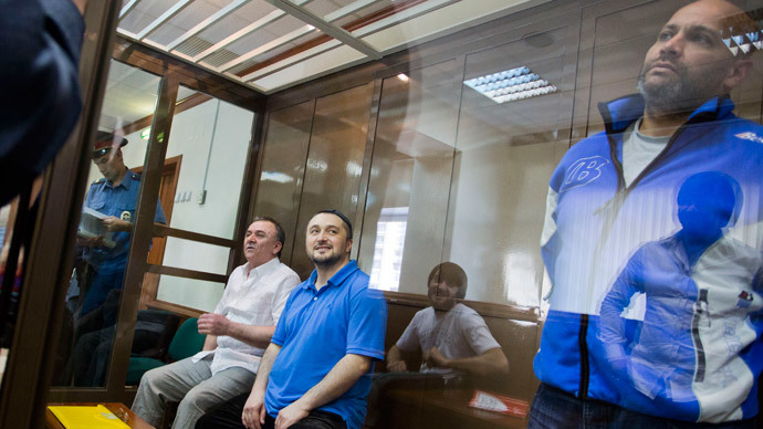 Suspects in the murder case of Russian investigative journalist Anna Politkovskaya, Rustam Makhmudov (2nd L), who is suspected of gunning down the renowned journalist and Kremlin critic Anna Politkovskaya, and his co-defendants, Lom-Ali Gaitukayev (L), who is accused of organising the crime along with former Moscow police officer, Sergei Khadzhikurbanov (R), looking on from a glass cage in Moscow's City Court.(AFP Photo / Evgeny Feldman)