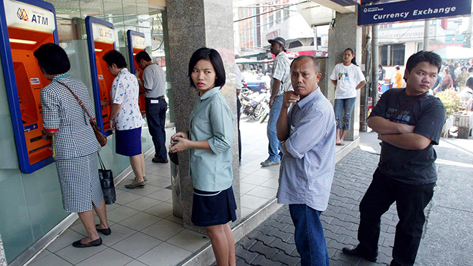 Thai bank clients queue to withdraw money from ATMs in Bangkok (AFP Photo)