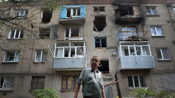 A local resident stands in front of the blown out windows and walls of a residential building after it was hit by mortar shells during clashes between the Ukrainian army and anti-Kiev forces in the eastern Ukrainian city of Slavyansk, on June 11, 2014. (AFP Photo/Daniel Mihailescu)