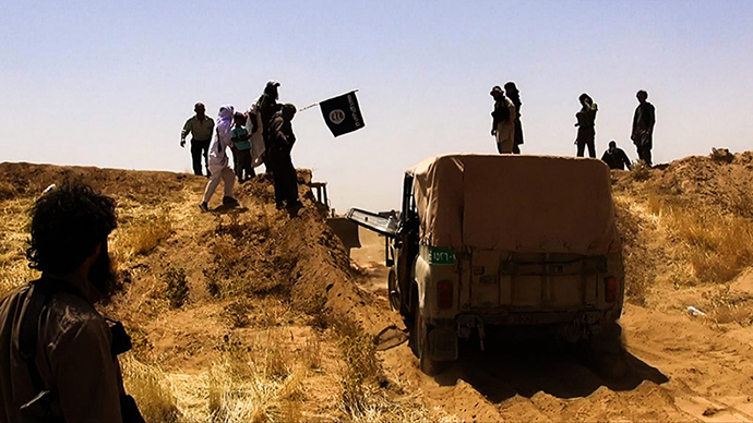 A file image made available by the jihadist Twitter account Al-Baraka news on June 9, 2014 allegedly shows Islamic State of Iraq and the Levant (ISIL) militants waving the trademark Jihadits flag as vehicles drive on a newly cut road through the Syrian-Iraqi border between the Iraqi Nineveh province and the Syrian town of Al-Hasakah (AFP Photo)