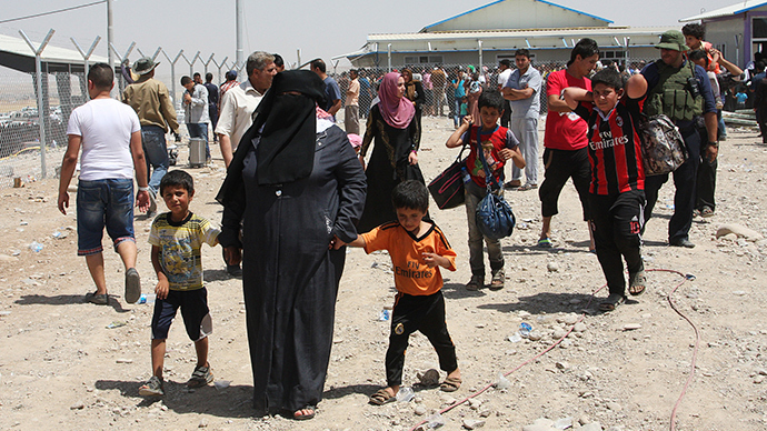 Families fleeing the violence in the Iraqi city of Mosul wait at a checkpoint in outskirts of Arbil, in Iraq's Kurdistan region, June 10, 2014 (Reuters / Azad Lashkari)
