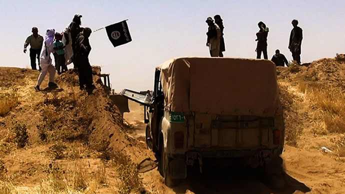 A file image made available by the jihadist Twitter account Al-Baraka news on June 9, 2014 allegedly shows Islamic State of Iraq and the Levant (ISIL) militants waving the trademark Jihadits flag as vehicles drive on a newly cut road through the Syrian-Iraqi border between the Iraqi Nineveh province and the Syrian town of Al-Hasakah. (AFP Photo)