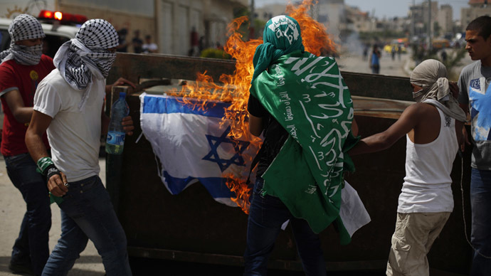 Palestinian protesters burn an Israeli flag during clashes with Israeli troops near Israel's Ofer Prison, near the West Bank city of Ramallah May 16, 2014. (Reuters/Mohamad Torokman)