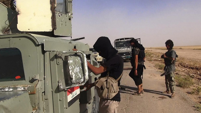 Islamic State of Iraq and the Levant (ISIL) militants inspecting abandoned Iraqi army vehicles at an undisclosed location close to the Iraqi-Syrian border, in the district of Sinjar, northwest Iraq. (AFP Photo / HO / Albaraka News)