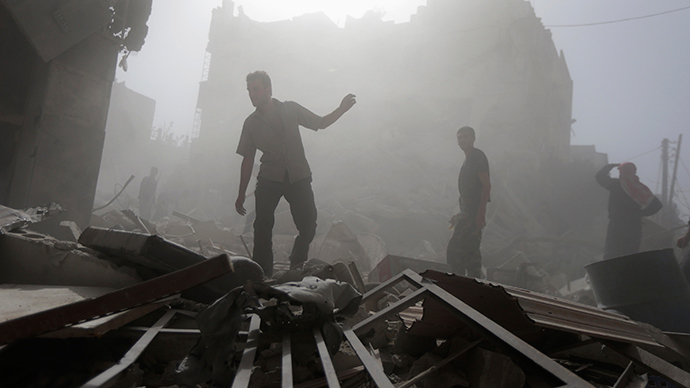 Residents inspect a damaged site after what activists say were four air strikes by forces loyal to Syria's President Bashar al-Assad in Douma, eastern al-Ghouta, near Damascus September 24, 2014 (Reuters / Bassam Khabieh)