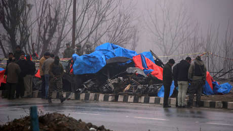 Investigadores inspecionam os restos de um ônibus destruído por um homem-bomba em Pulwama (Índia).