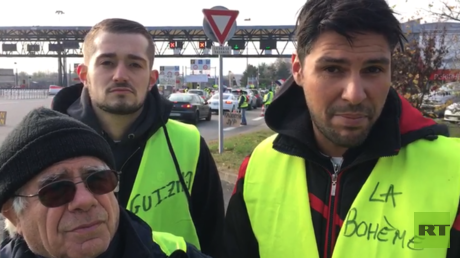 Organisatoren der Gelbwesten in Lyon im Gespräch mit RT Deutsch vor einer Maut-Station, die als 