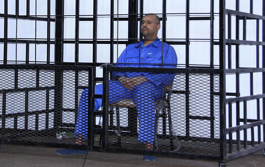 Saif al-Islam Gaddafi, son of late Libyan leader Muammar Gaddafi, attends a hearing behind bars in a courtroom in Zintan May 25, 2014. © Stringer