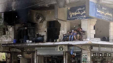 Residents sit on a couch on a balcony of a damaged building in Aleppo's al-Shaar neighboirhood, Syria, August 1, 2015. © Abdalrhman Ismail 