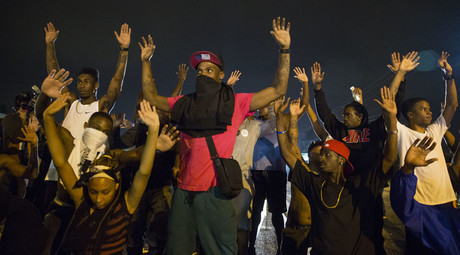 Demonstrators confront police with their arms raised during on-going demonstrations to protest against the shooting of Michael Brown, in Ferguson, Missouri, August 16, 2014. © Lucas Jackson 