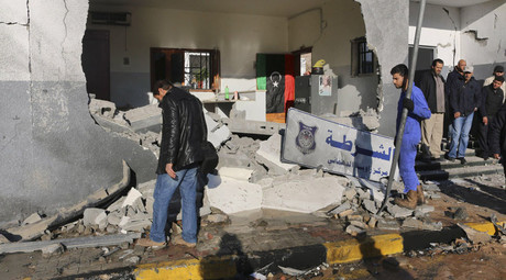 Civilians and security personnel stand at the scene of an explosion at a police station in the Libyan capital Tripoli March 12, 2015. © Hani Amara