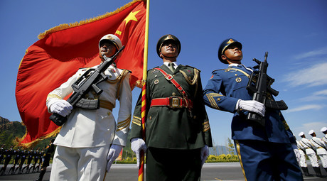 Officers and soldiers of China's People's Liberation Army hold a flag and weapons during a training session for a military parade to mark the 70th anniversary of the end of the World War Two, at a military base in Beijing, China, August 22, 2015. © Damir Sagolj