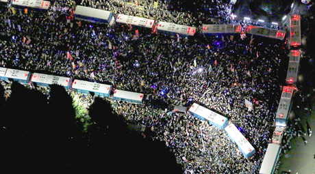 An aerial view shows protesters gathering at a rally against Japan's Prime Minister Shinzo Abe's security bill and his administration, as police use parked buses to block protesters in front of the parliament building in Tokyo, in this photo taken by Kyodo September 14, 2015. © Kyodo 