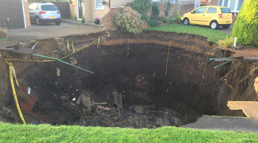 Massive sinkhole swallows suburban street, families evacuated