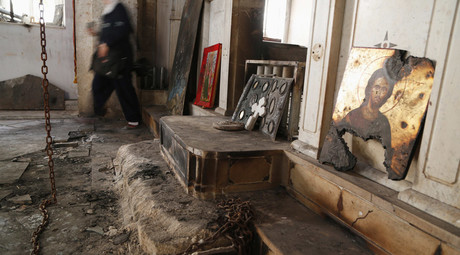 A woman walks inside a damaged church in Maaloula, Syria © Omar Sanadiki 