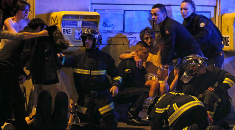 French fire brigade members aid an injured individual near the Bataclan concert hall following fatal shootings in Paris, France, November 13, 2015 © Christian Hartmann