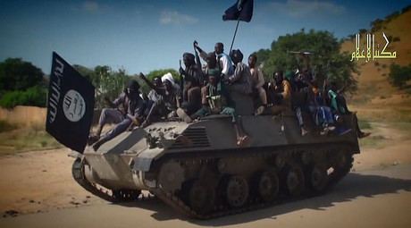A screengrab taken on November 9, 2014 from a new Boko Haram video released by the Nigerian Islamist extremist group Boko Haram and obtained by AFP shows Boko Haram fighters parading on a tank in an unidentified town. © AFP Photo
