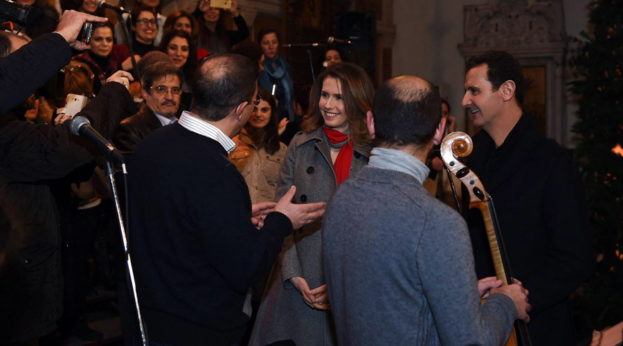 Syrian President Bashar Assad (R) and his wife Asma al-Assad (3rd-R) attending a Christmas choral presentation at the Lady of Damascus Catholic Church in the Syrian capital on December 18, 2015. © HO