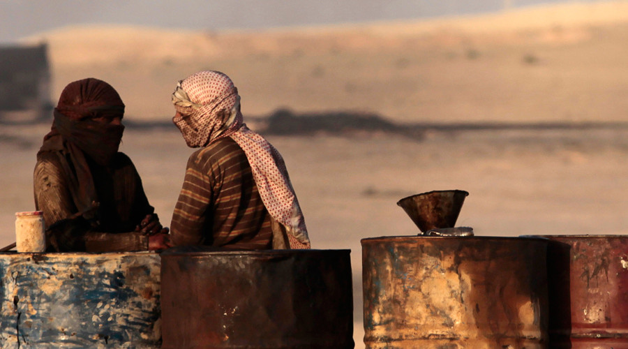 People talk as they stand next to oil barrels at a makeshift oil refinery site in al-Mansoura village in Raqqa's countryside  Hamid Khatib