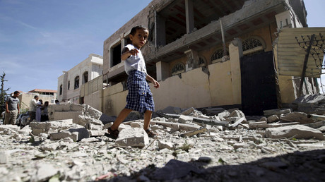 A boy walks past the a house damaged by a Saudi-led air strike in Yemen's capital Sanaa. © Mohamed al-Sayaghi