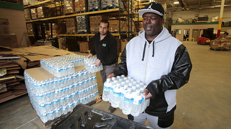 Man picks up bottled water from the Food Bank of Eastern Michigan to deliver to a school after elevated lead levels were found in the city's water in Flint, Michigan. © Rebecca Cook
