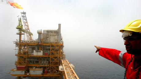 An Iranian man points to an oil production platform at the Soroush oil fields in the Persian Gulf, 1,250 km (776 miles) south of the capital Tehran © Raheb Homavandi CJF