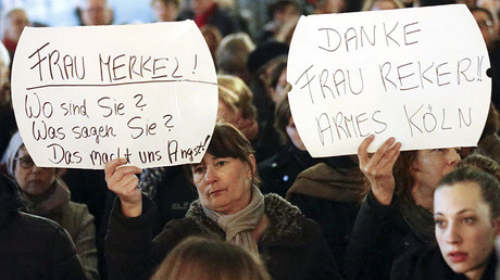 Women hold up placards that read 