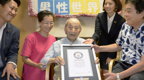 Japanese Yasutaro Koide (C), 112, receives the Guinness World Records certificate as he is formally recognized as the world's oldest man, at a nursing home in Nagoya, central Japan © Kyodo