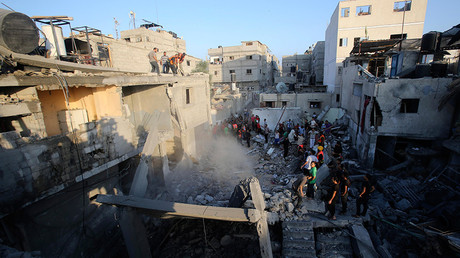 FILE PHOTO: Palestinians and rescue workers stand near the rubble of a house which police said was destroyed in an Israeli air strike in Khan Younis in the southern Gaza Strip July 10, 2014 © Ibraheem Abu Mustafa
