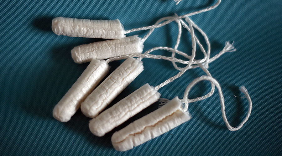 ‘Begging for a tampon’: Tory tax forces women to use newspapers & socks, claims charity