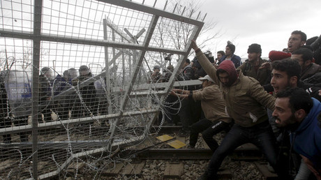 Stranded refugees and migrants try to bring down part of the border fence during a protest at the Greek-Macedonian border, near the Greek village of Idomeni, February 29, 2016. © Alexandros Avramidis